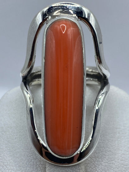 Anillo de coral en plata luciendo en dedo, mostrando el color cálido naranja rojizo