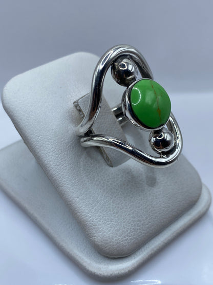 Anillo en plata con piedra verde vista lateral en mano de mujer