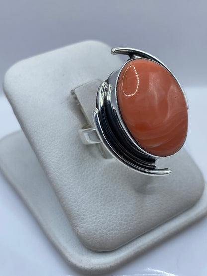 Vista lateral del anillo con coral engastado en plata .925 mostrando el volumen