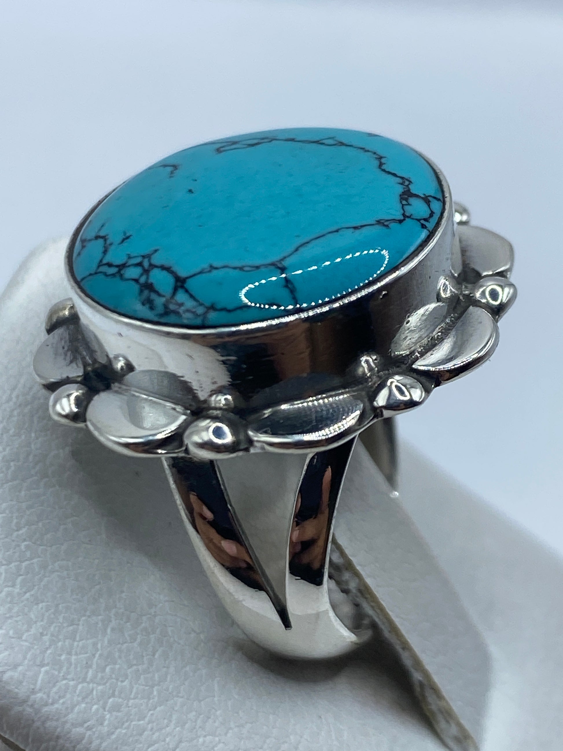 Detalle lateral del anillo de turquesa con marco ornamental de plata