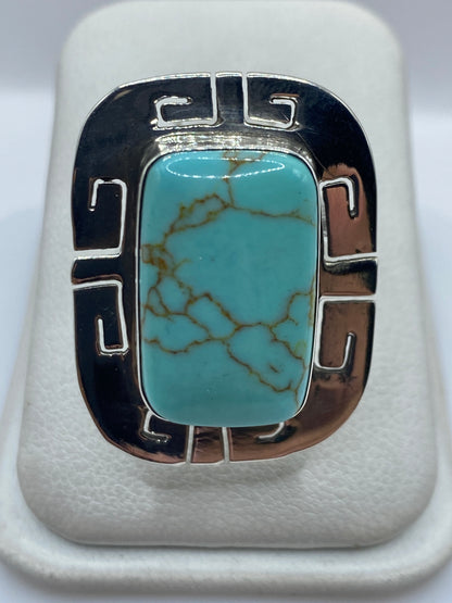 Anillo de plata ajustable con turquesa azul cielo y motivos geométricos prehispánicos, vista frontal