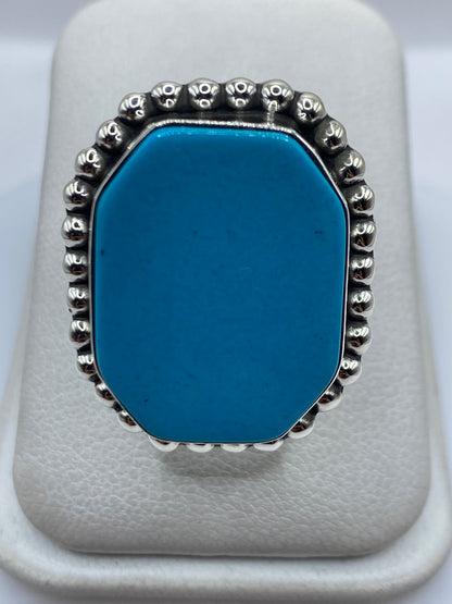 Anillo de plata con turquesa azul cielo engastada, detalle del granulado plateado alrededor