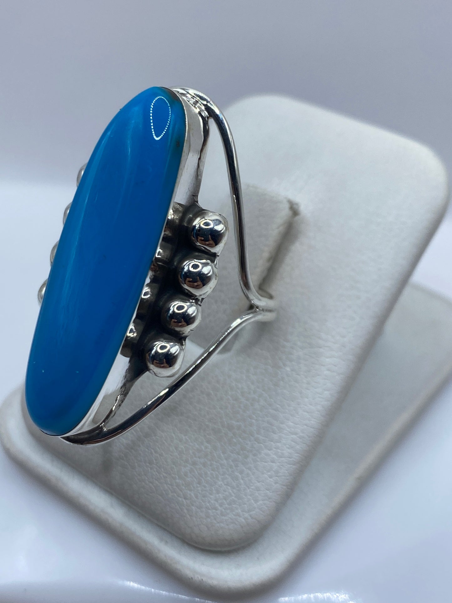 Anillo de plata Taxco en dedo de mujer, mostrando el color azul intenso de la piedra