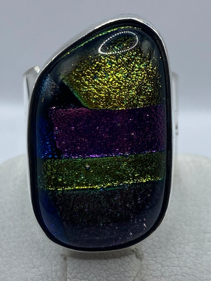 Anillo colocado en el dedo mostrando la incrustación de piedra multicolor en uso