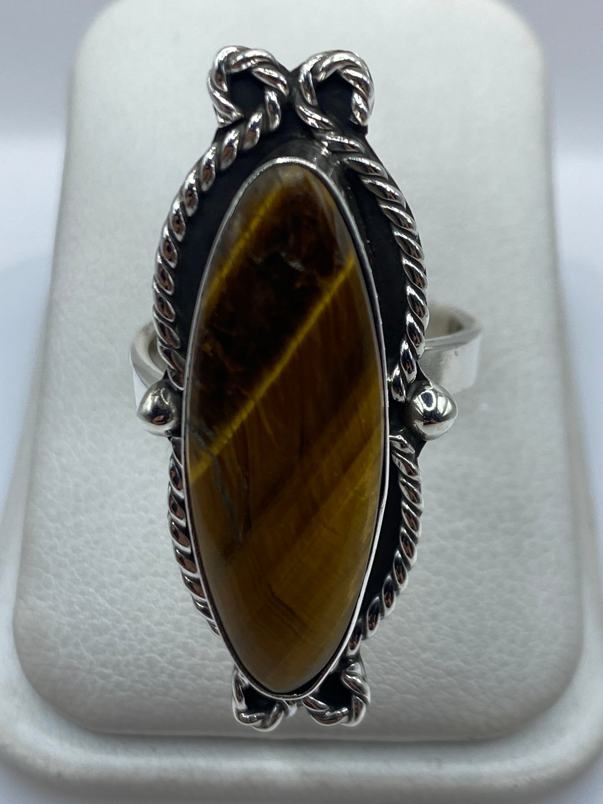Anillo de plata .925 ajustable con piedra cafe en la mano de una mujer