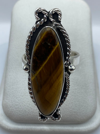 Anillo de plata .925 ajustable con piedra cafe en la mano de una mujer