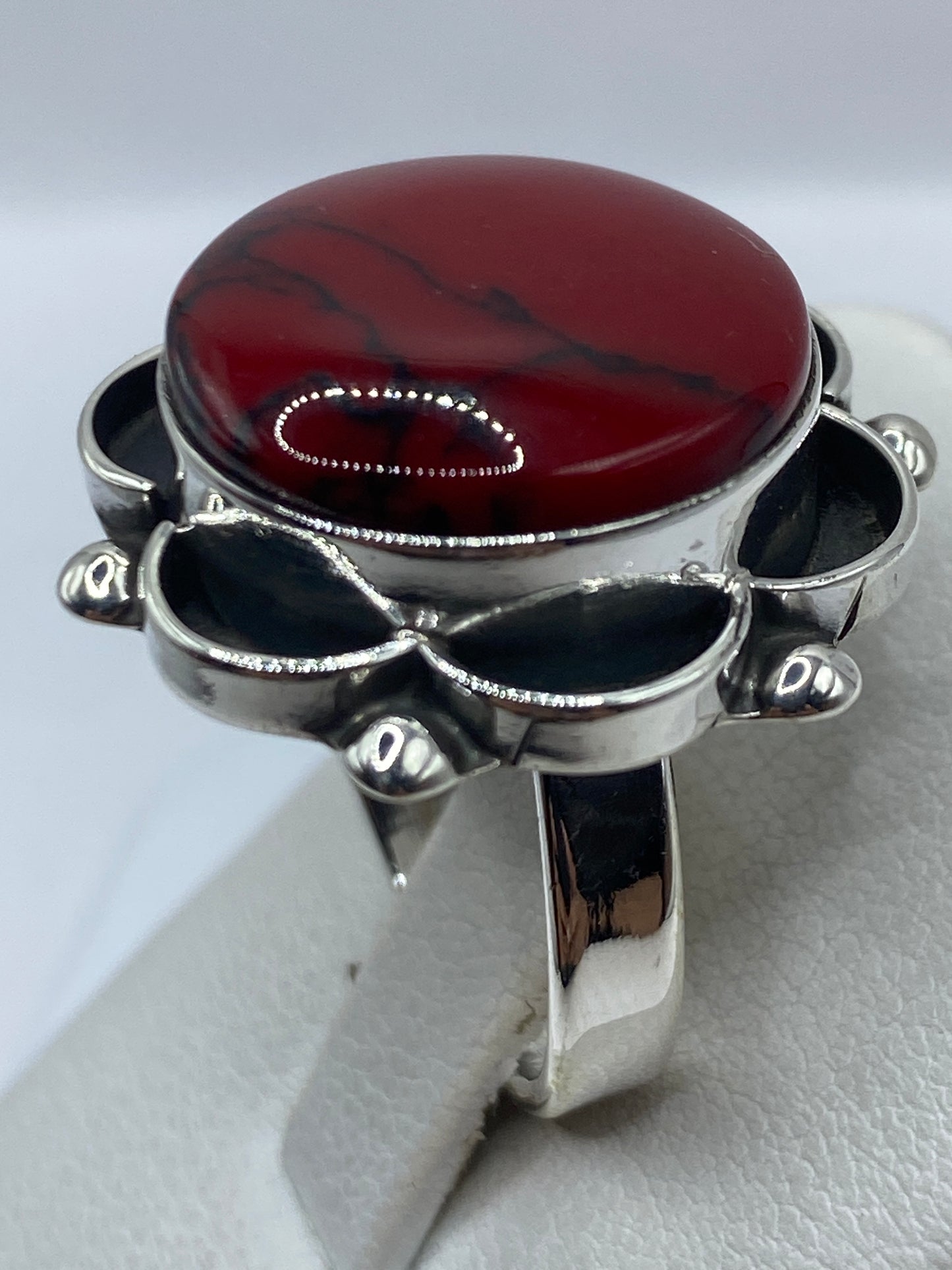 Anillo floral de coral y onix en dedo, mostrando el tamaño ajustable