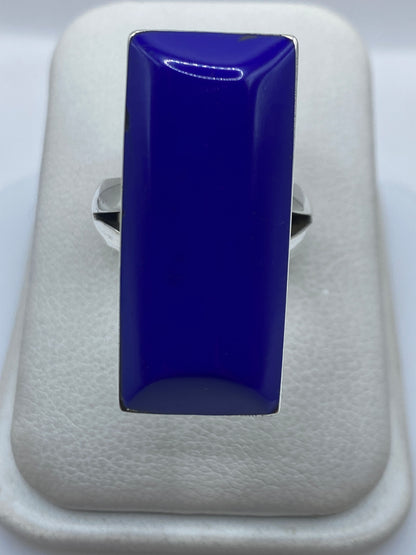 Anillo de plata con piedra azul rectangular en mano de mujer