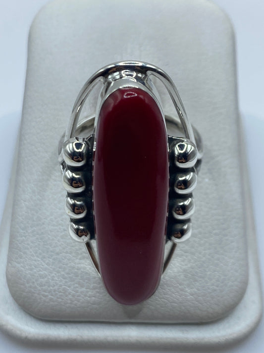 Anillo de plata .925 con piedra roja engastada, vista frontal sobre almohadilla blanca