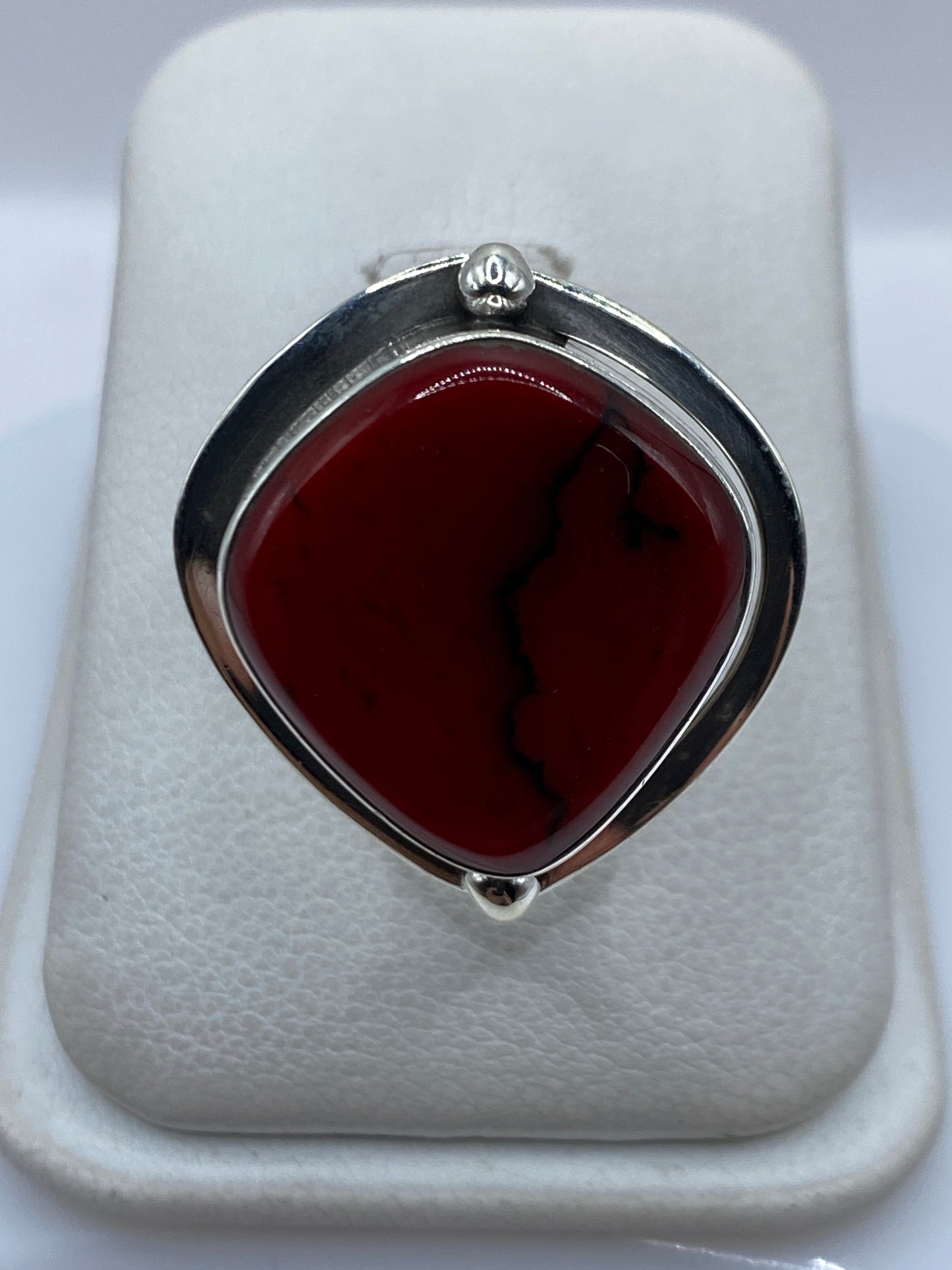 Anillo ajustable de plata con coral rojo engastado, vista superior en estuche