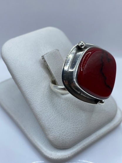 Anillo de coral rojo en plata .925 colocado en dedo, vista lateral