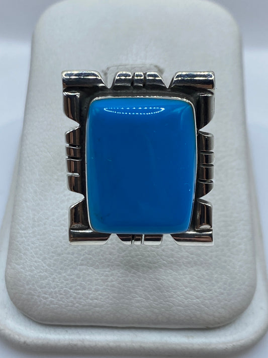 Anillo de plata ajustable con piedra azul en marco arquitectónico, vista frontal sobre fondo blanco