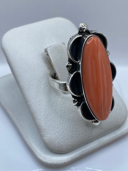 Detalle lateral del anillo: coral pulido y plata con acabado brillante