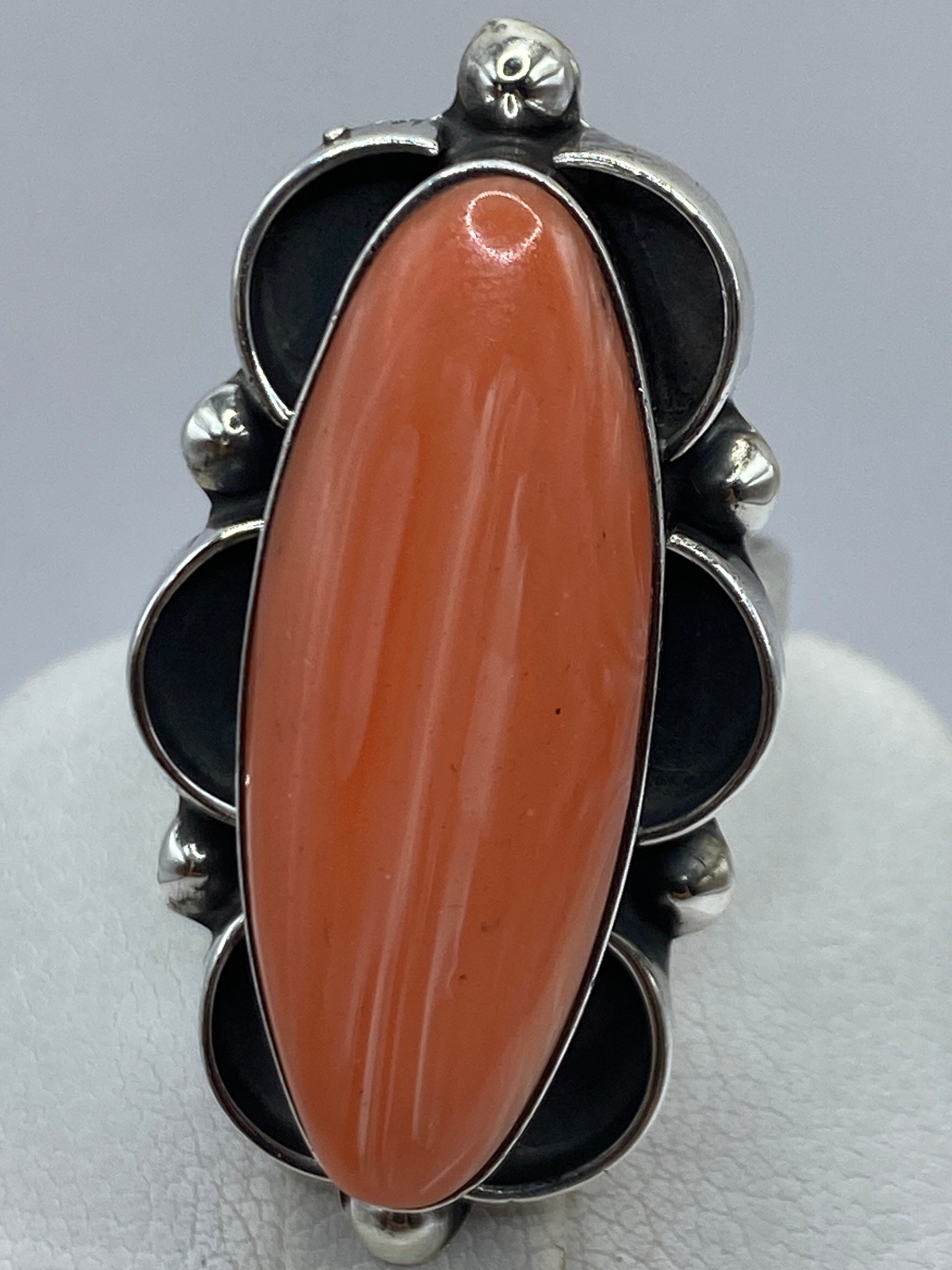 Anillo puesto en dedo mostrando el color vivo del coral y el ajuste cómodo