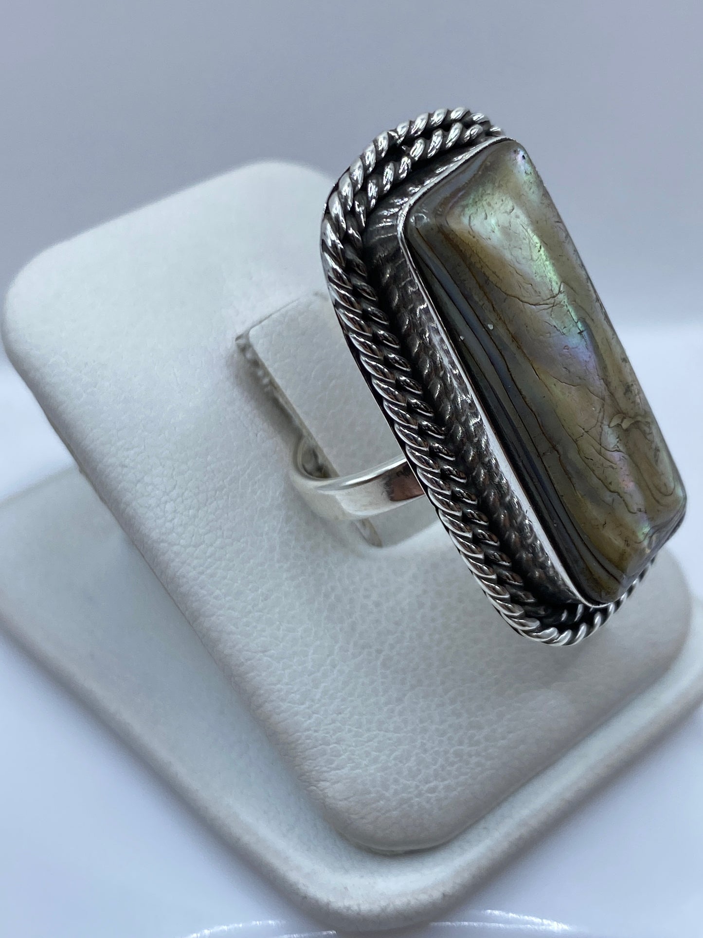 Anillo de plata .925 en dedo mostrando la piedra y el marco textil trenzado