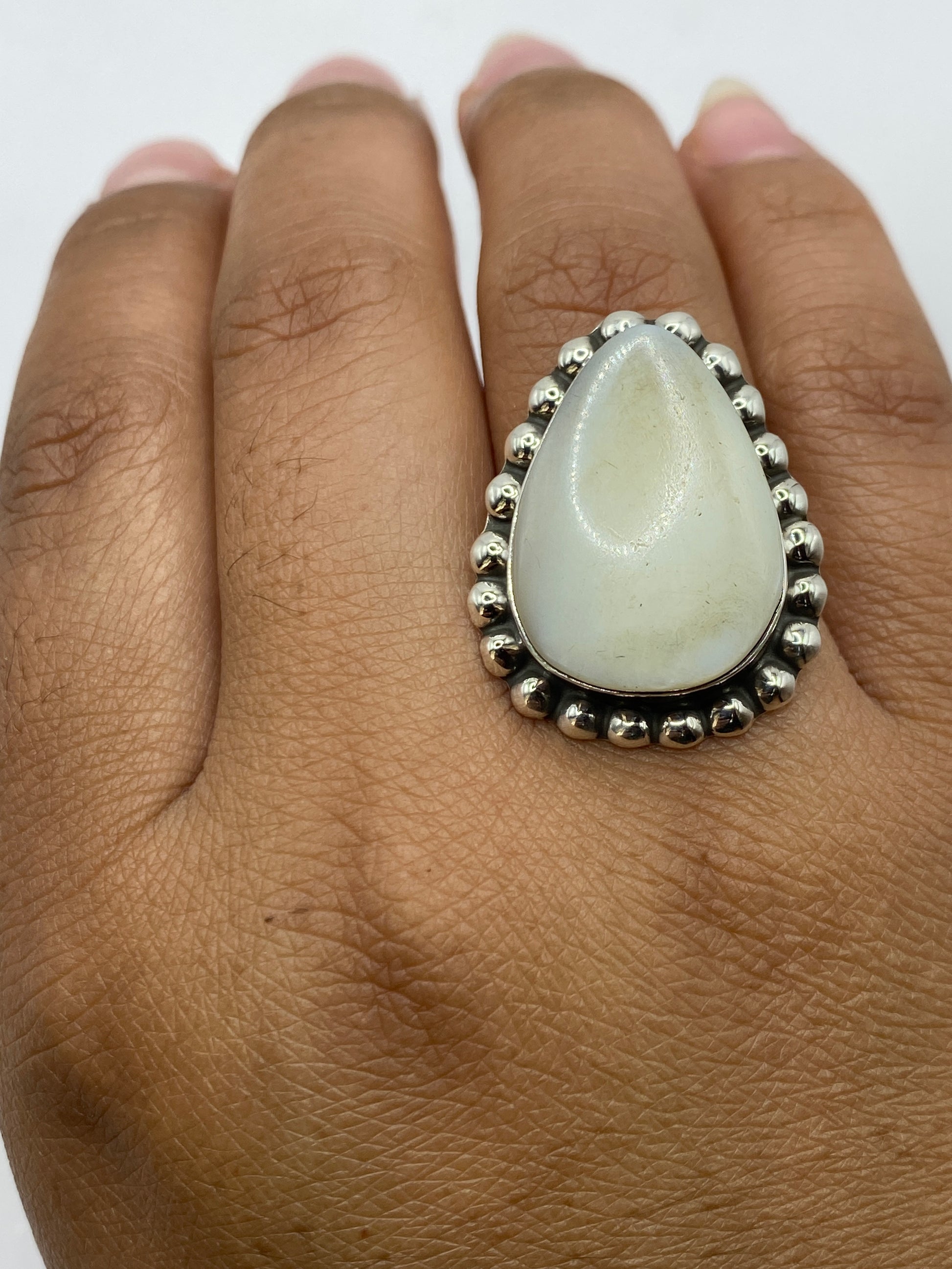 Anillo ajustable de plata con perla en la mano, mostrando comodidad de uso