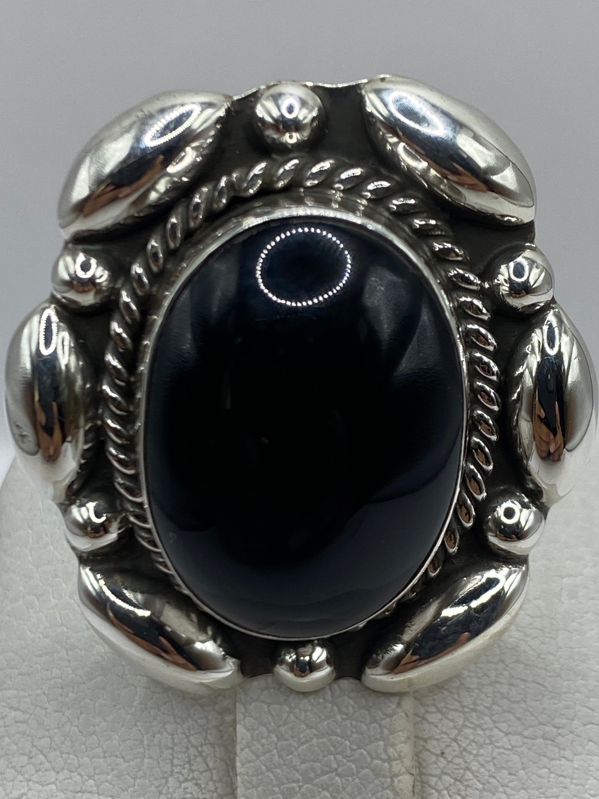 Anillo puesto en mano de mujer, ónix brillante contra la piel