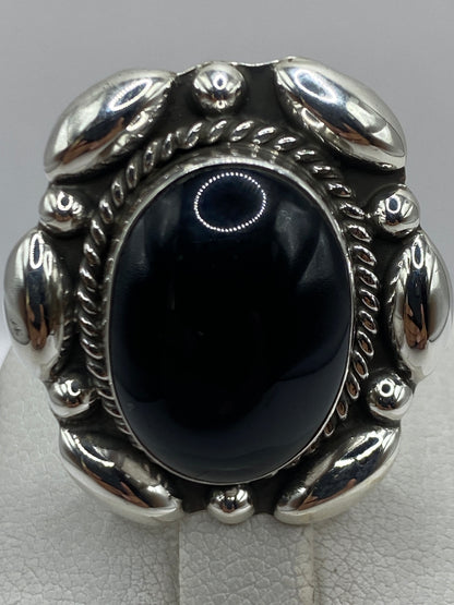 Anillo puesto en mano de mujer, ónix brillante contra la piel