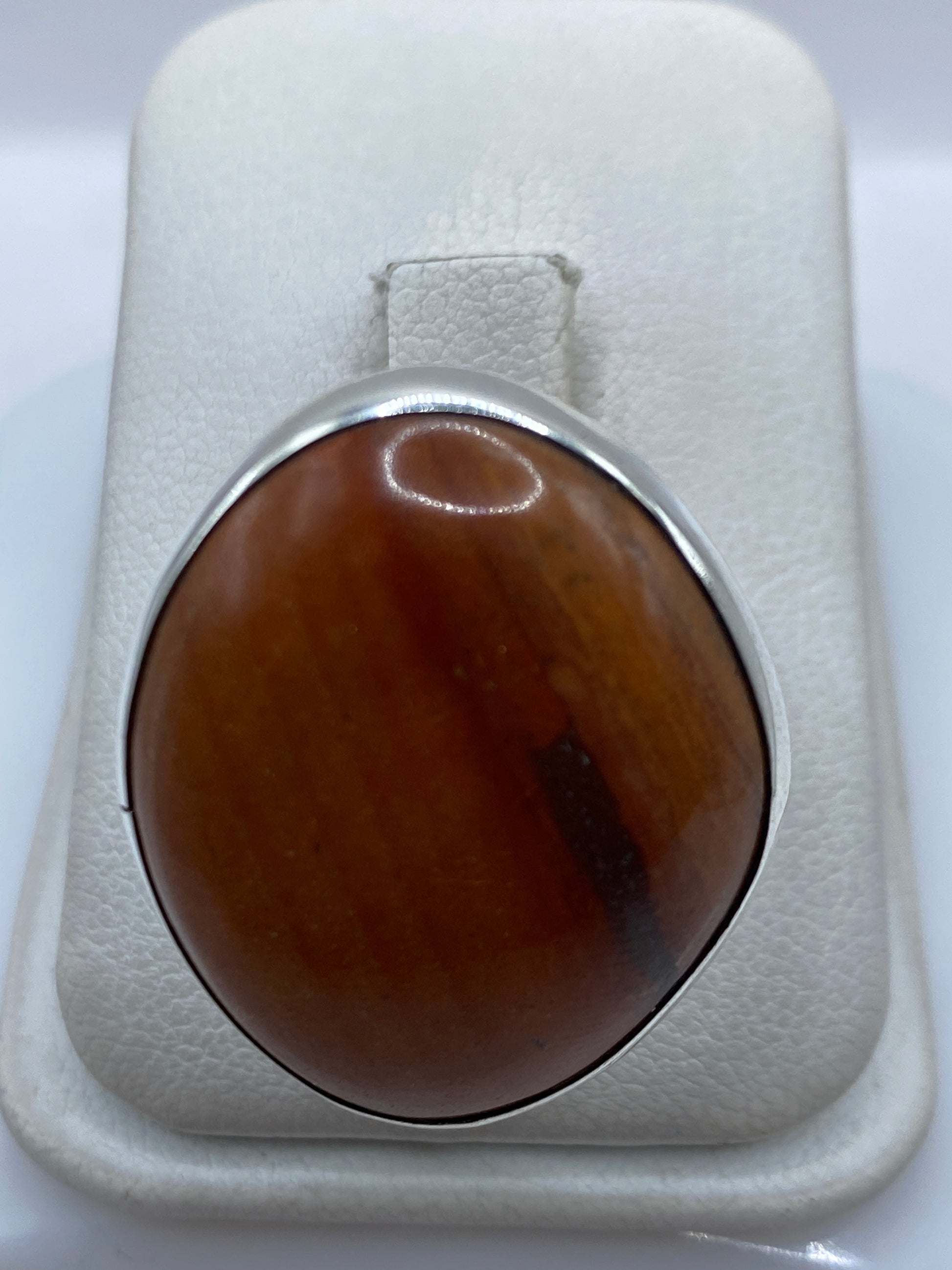Anillo de plata .950 ajustable con piedra café engastada, vista superior en estuche blanco