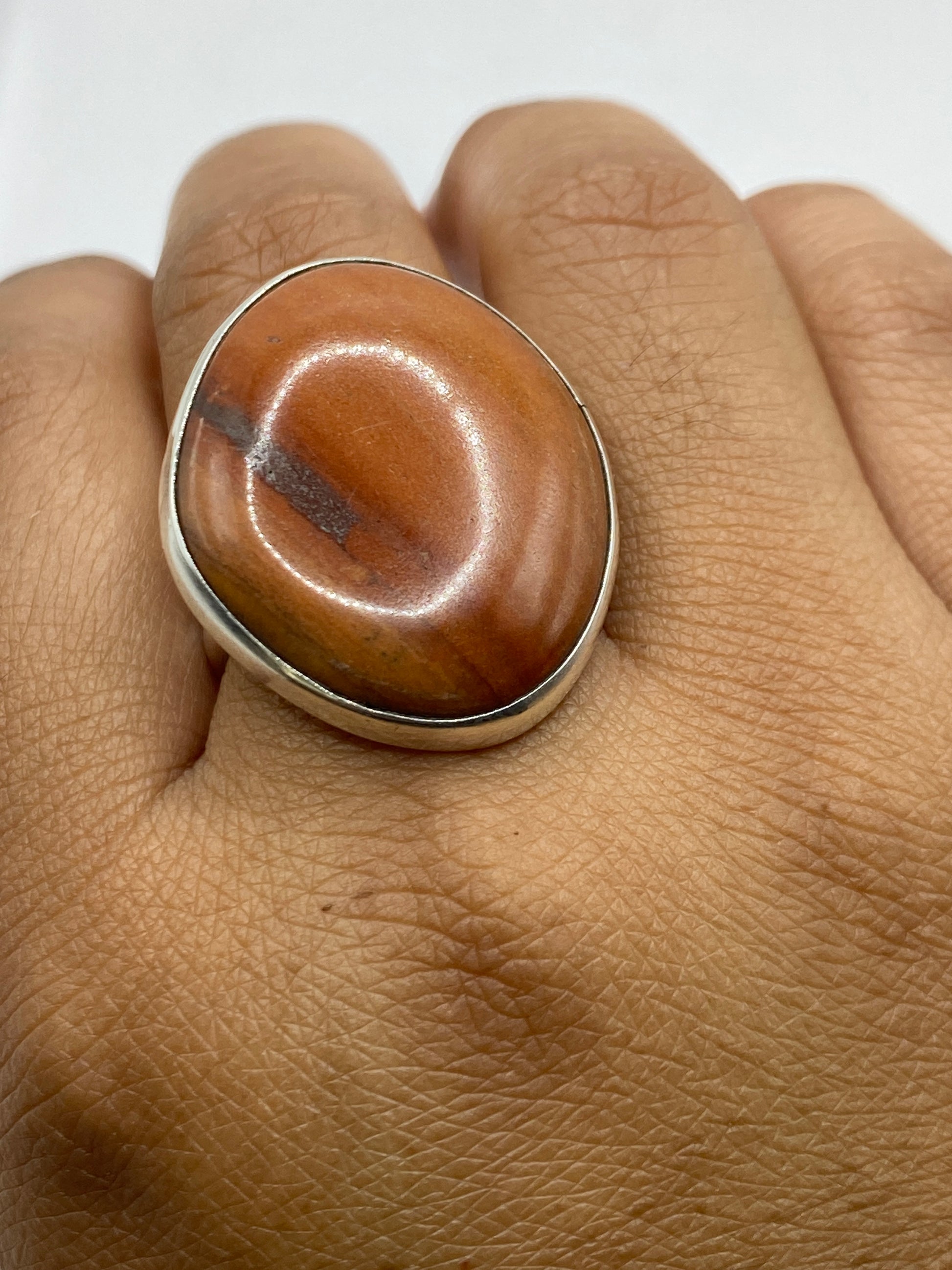 Anillo de plata .950 puesto en dedo, mostrando calidez de la piedra café