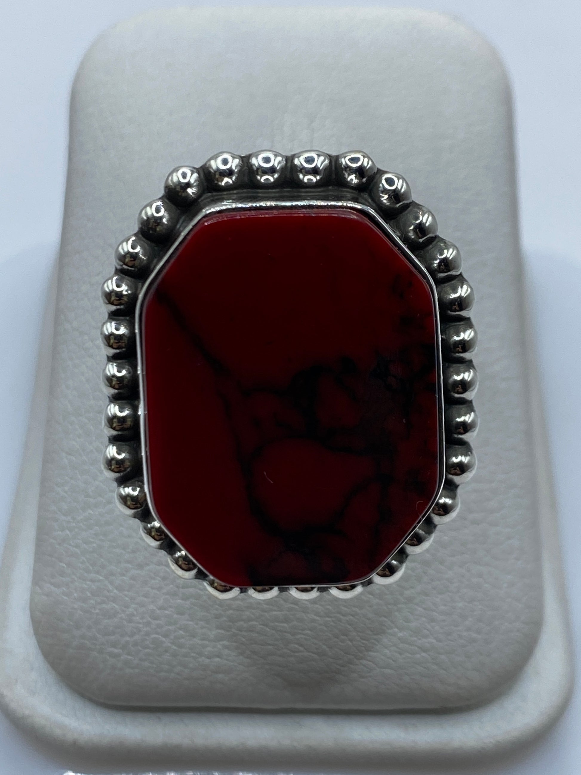 Anillo de plata con coral rojo engastado, visto de frente en estuche blanco