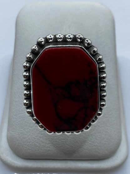 Anillo de plata con coral rojo engastado, visto de frente en estuche blanco