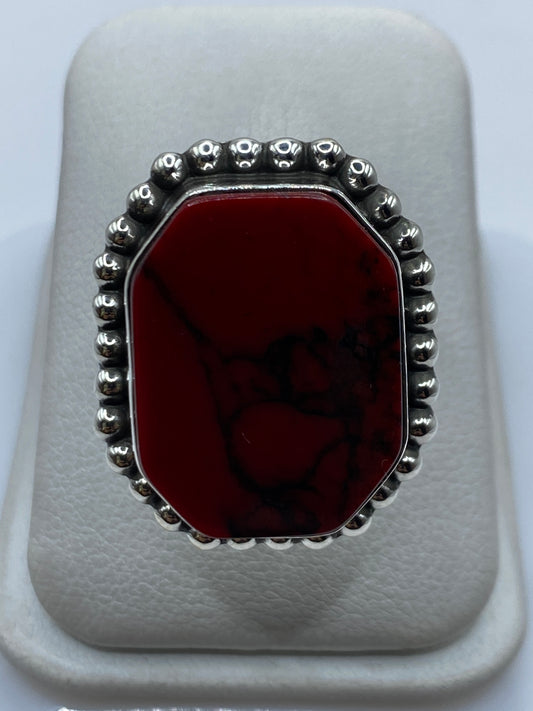 Anillo de plata con coral rojo engastado, visto de frente en estuche blanco