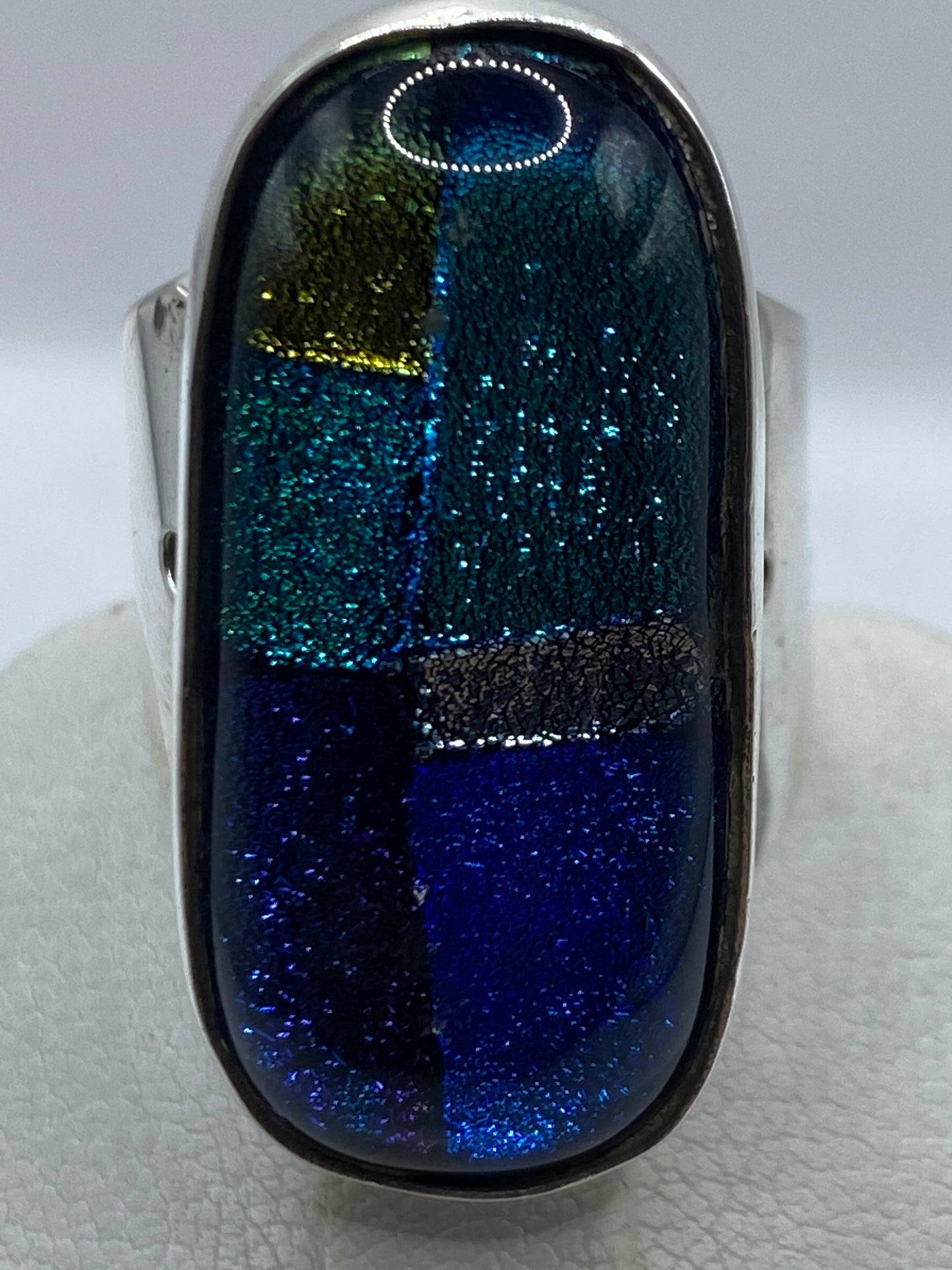 Detalle del acabado pulido y la alineación de piedras multicolores en el anillo