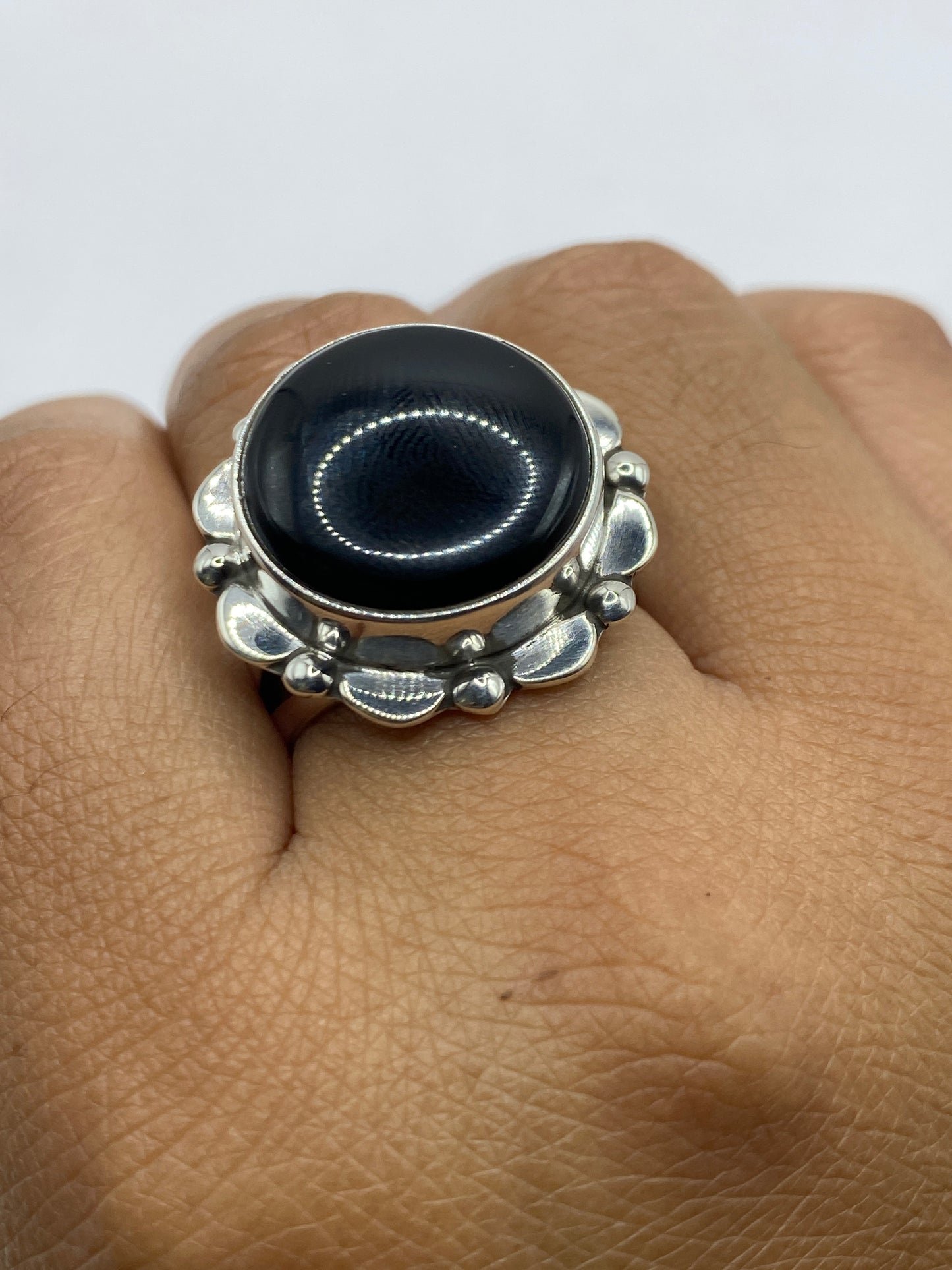 Anillo de plata con ónix negro sobre fondo blanco, vista de arriba