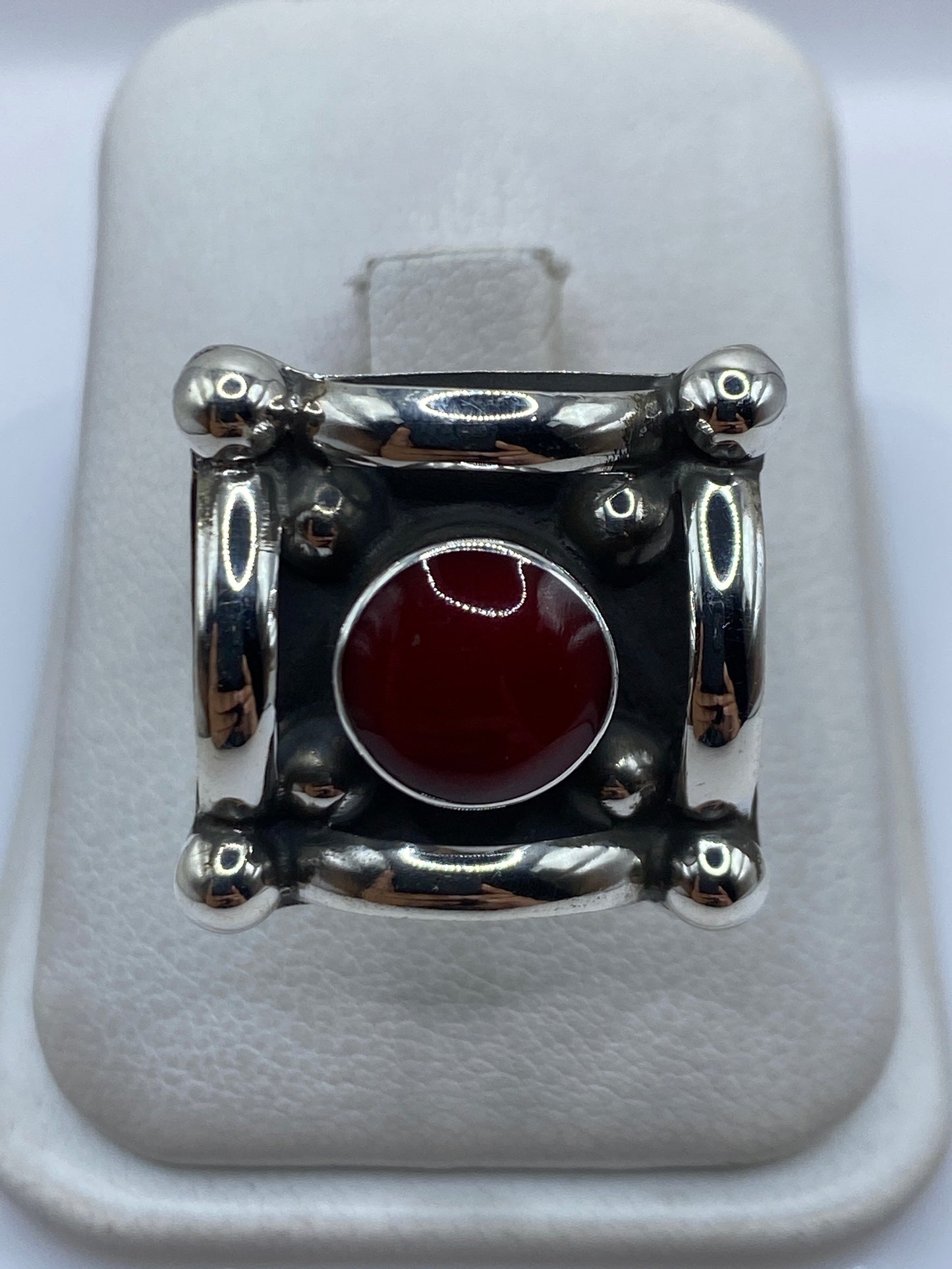 Anillo de plata ajustable con coral rojo engastado en diseño geométrico, vista frontal