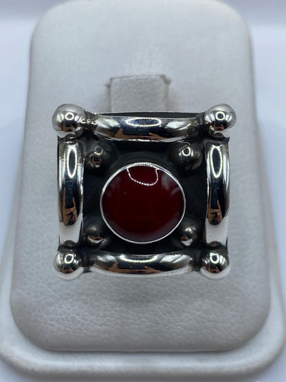 Anillo de plata ajustable con coral rojo engastado en diseño geométrico, vista frontal