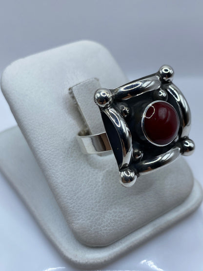 Anillo de plata con coral rojo en la mano de una mujer, lado lateral