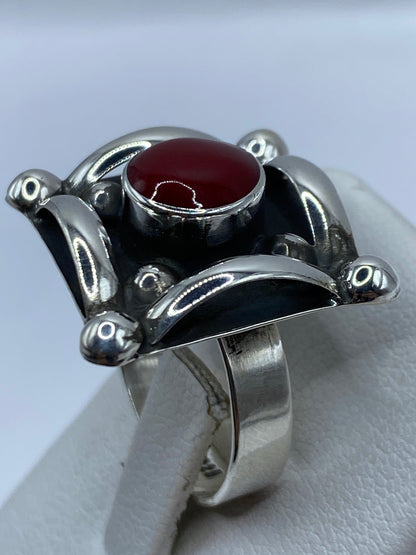 Detalle del engaste a mano del coral rojo y las esferas de plata maciza