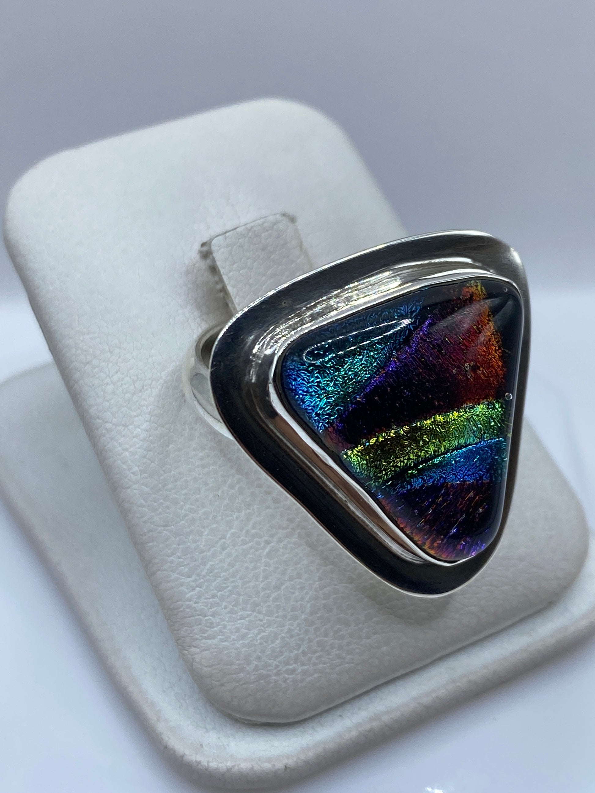 Detalle de la piedra multicolor con reflejos azules, amarillos y rojos en el anillo