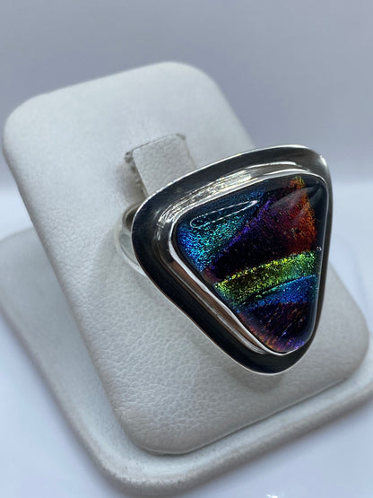 Detalle de la piedra multicolor con reflejos azules, amarillos y rojos en el anillo