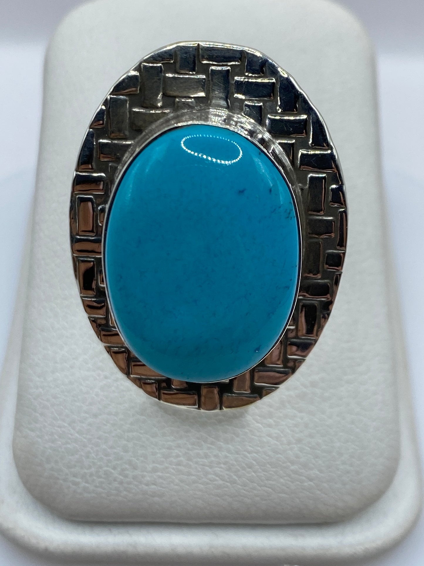 Anillo de plata ajustable con turquesa azul cielo en la mano
