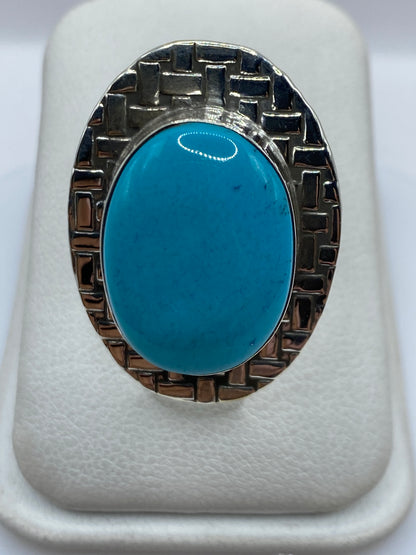 Anillo de plata ajustable con turquesa azul cielo en la mano