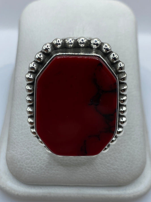 Anillo de plata .925 con coral rojo engastado, visto de frente sobre fondo blanco