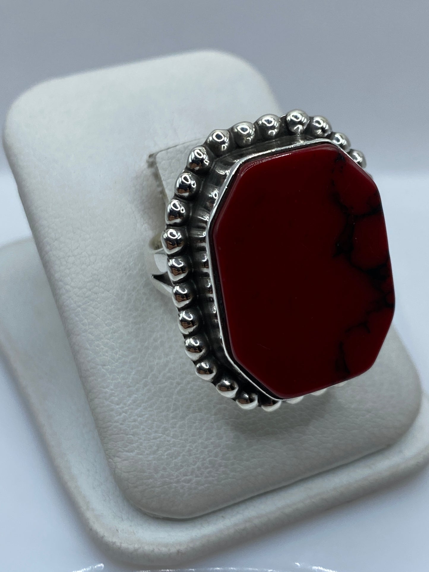 Vista lateral del anillo de plata con granulado y coral rojo