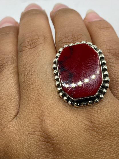 Anillo en la mano mostrando el color burgundy del coral y la textura del granulado