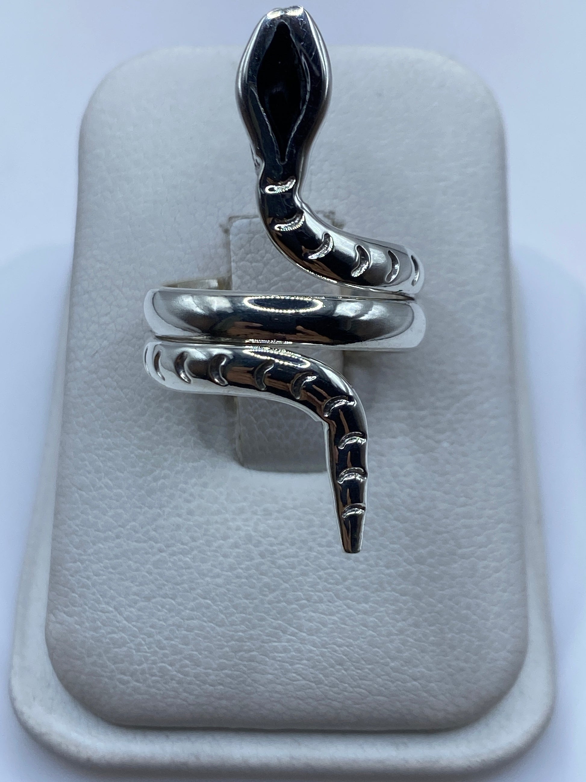 Anillo giratorio de plata .925 en forma de serpiente enrollada, sobre almohada blanca