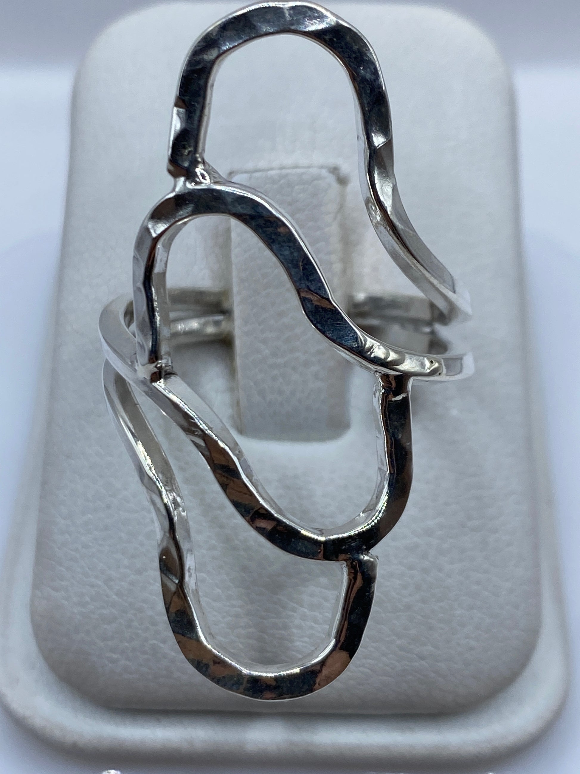 Anillo de plata repujado con tres cuerpos fluidos conectados en relieve