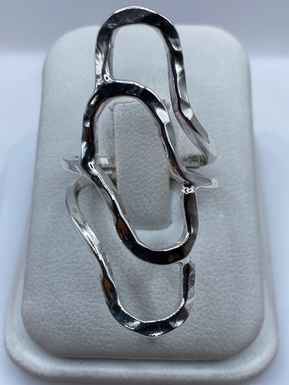 Anillo de plata repujado con diseño fluido en relieve, visto desde arriba