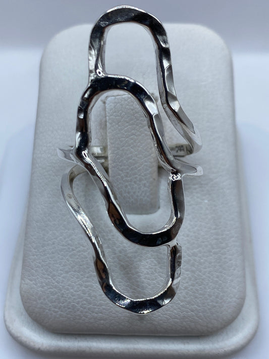 Anillo de plata repujado con diseño fluido en relieve, visto desde arriba