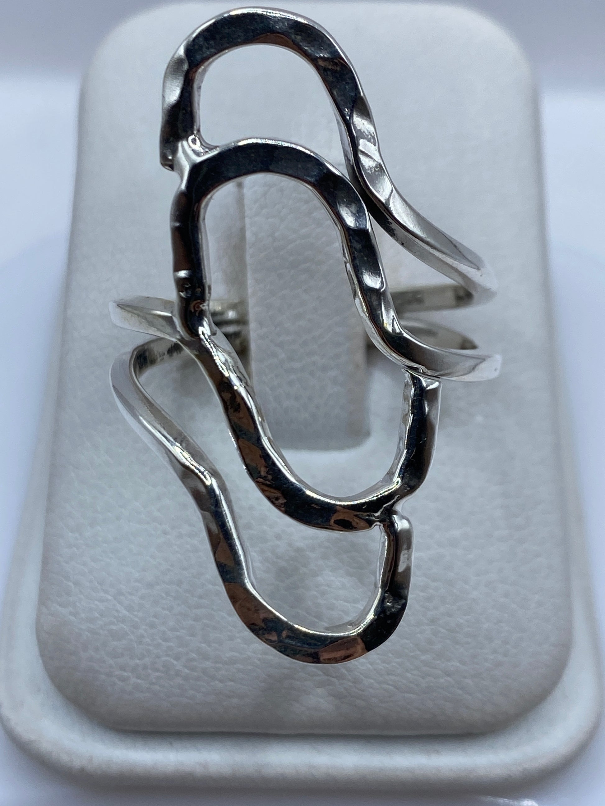 Anillo de plata repujada con relieve geométrico en mano de mujer