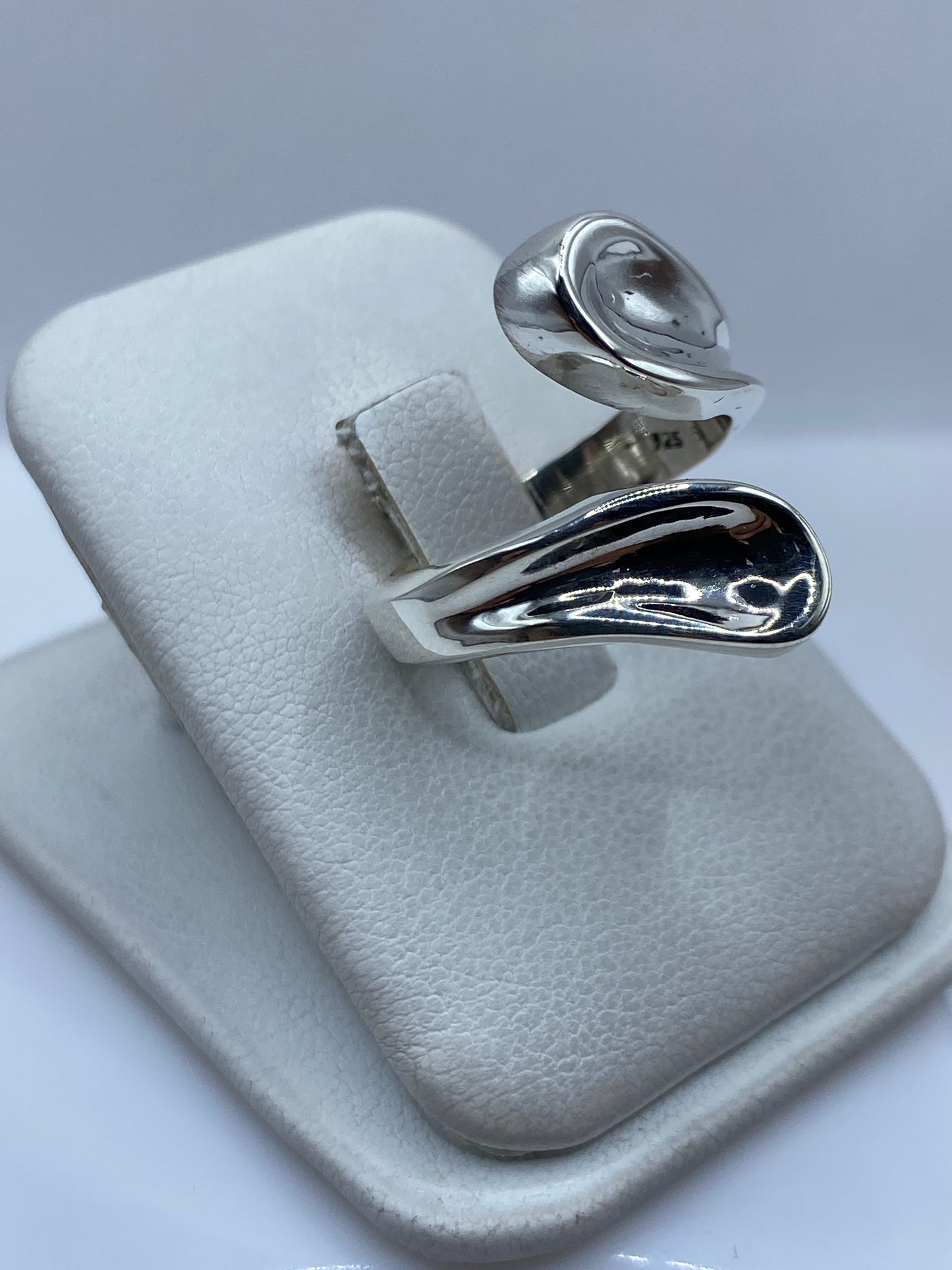 Detalle del anillo de cartoneado en la mano, mostrando la forma orgánica y voluminosa