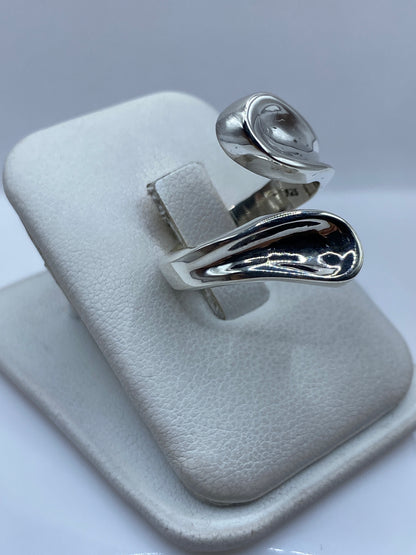 Detalle del anillo de cartoneado en la mano, mostrando la forma orgánica y voluminosa