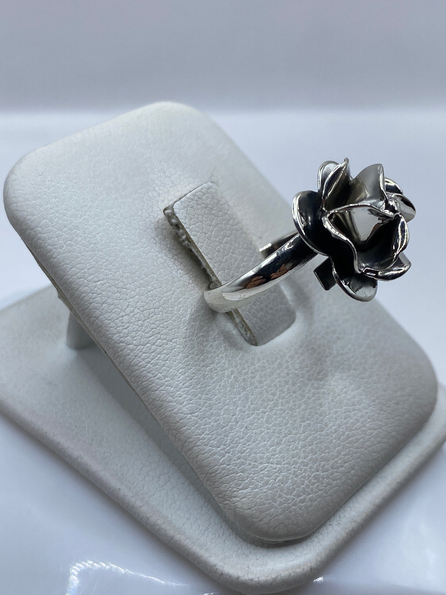 Anillo floral en la mano mostrando el diseño escultórico de pétalos en relieve