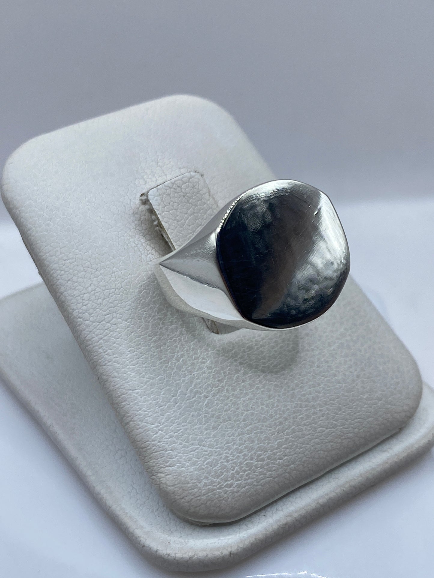 Vista frontal del anillo mostrando la cara de onix espejo engastada en plata