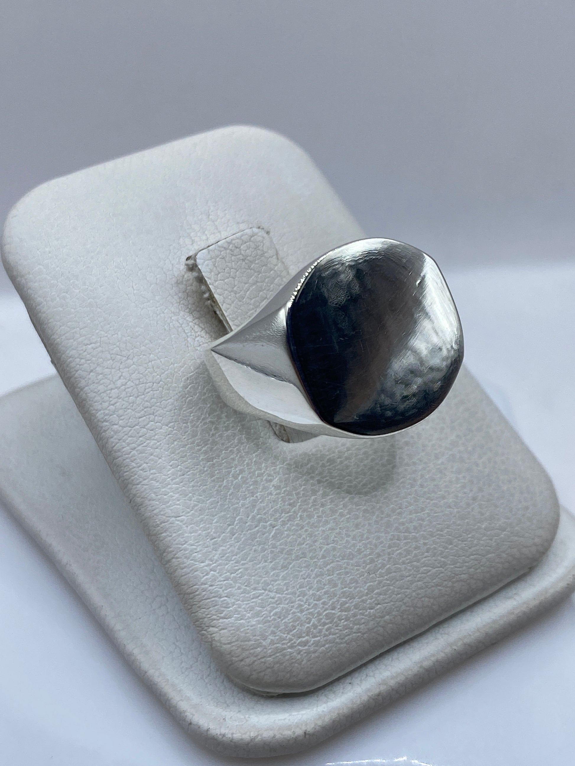 Vista frontal del anillo mostrando la cara de onix espejo engastada en plata